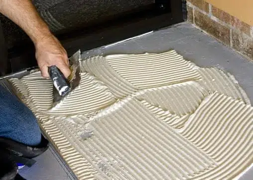 mão de profissional segurando aplicador e aplicando revestimento de argamassa em alvenaria estrutural