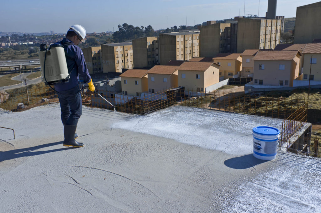 agente de cura sendo aplicado sobre superfície de concreto durante processo de concretagem