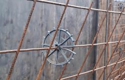 Detalhe do espaçador circular em viga, mostrando o contato mínimo com a fôrma para acabamento perfeito.
